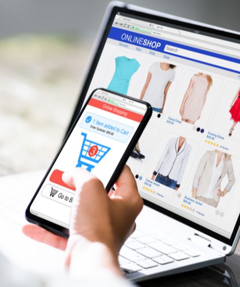 Persona comprando ropa en línea desde portátil y smartphone